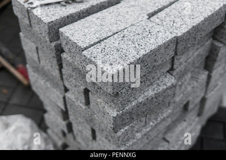 Bürgersteig Kopfsteinpflaster in den Stapel auf der Straße. Beton oder Granit grau square Gehwegplatten für bürgersteig Bau. Industrie Herstellung oder Gebäude Konzept. Baumaterial Stockfoto