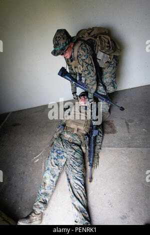 Us Marine Corps Lance Cpl. Robert J. Carolus III eine mortarman zu Waffen, Bataillon Landung Team 1st Battalion, 5th Marines, 31 Marine Expeditionary Unit, zieht einen simulierten Unfall Sicherheit bei der Durchführung von Urban Warfare Ausbildung bei der Bekämpfung der Stadt auf Camp Hansen, Okinawa, Japan, Jan. 8, 2016. Die Marines der BLT 1/5, 31 MEU, derzeit vor der Bereitstellung für die kommende Frühjahr Bereitstellung in der Asien-Pazifik-Region. (U.S. Marine Corps Foto von Cpl. Darien J. Bjorndal, 31 Marine Expeditionary Unit/Freigegeben) Stockfoto