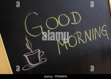 Guten Morgen Nachricht mit Kaffee Tasse auf die Tafel geschrieben. Stockfoto