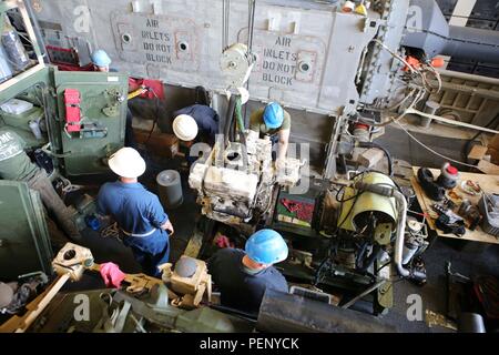 Us-Marines mit dem 26 Marine Expeditionary Unit (26 MEU) und Matrosen mit der kearsarge Amphibischen bereit, Gruppe, ersetzen Sie den Motor für ein leichtes gepanzertes Fahrzeug an Bord des amphibious Transport dock Schiff USS Arlington LPD (24), Jan. 15, 2016. Die 26. MEU ist mit der kearsarge Amphibious Ready Gruppe begonnen und bereitgestellt ist die regionale Sicherheit in den USA 5 Flotte Bereich der Betrieb aufrecht zu erhalten. (U.S. Marine Corps Foto von Cpl. Jeraco Jenkins/26 MEU bekämpfen Kamera/Freigegeben). Stockfoto