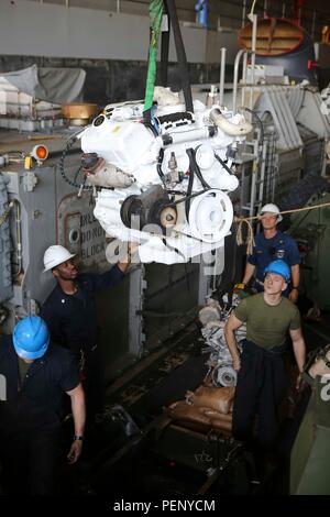 Marines der 26. MEU und Seeleute der Kearsarge Amphibious Ready Group führten am 15. Januar 2016 einen Motorenaustausch an Bord der USS Arlington (LPD 24) durch. Die Instandhaltungsarbeiten gewährleisten die Einsatzbereitschaft von Amphibienfahrzeugen und unterstützen die Einsatzfähigkeit während des Einsatzes. Die 26. MEU, die mit der Kearsarge ARG eingelaufen ist, ist für die regionale Sicherheit im Gebiet der 5. US-Flotte zuständig, führt maritime und amphibische Operationen durch und wartet Ausrüstung für nachhaltige Operationen auf See. Stockfoto