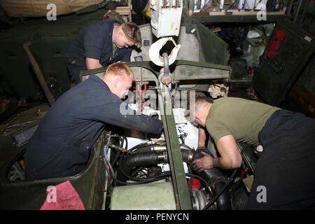 Die US-Marines der 26. MEU installierten am 16. Januar 2016 einen neuen Light gepanzerten Fahrzeugmotor an Bord der USS Arlington (LPD 24), während sie mit der Kearsarge Amphibious Ready Group eingesetzt wurden. Dieser Wartungsvorgang unterstützt die Betriebsbereitschaft und stellt sicher, dass die Fahrzeuge einsatzfähig für maritime und amphibische Aufgaben sind. Die 26. MEU, die mit der Kearsarge ARG begonnen wurde, führt regionale Sicherheitsoperationen im Gebiet der 5. US-Flotte durch, führt routinemäßige Inspektionen der Ausrüstung, technische Aufgaben und die Aufrechterhaltung amphibischer Einsatzkapazitäten durch. Stockfoto