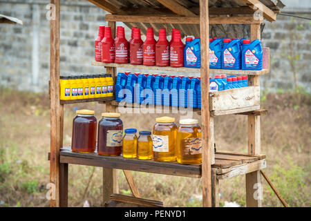 Bunte flaschen benzin sind ordentlich auf einem Stand aus Holz in Ganta, Liberia gefüttert Stockfoto