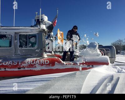 Petty Officer 2nd class Richard Clarke, III, ein Crew Mitglied an der Coast Guard Station Sandy Hook, New Jersey, schaufeln Schnee vom Deck eines Coast Guard 25-Fuß Antwort Boot - Klein, Jan. 24, 2016. Eine massive Schneesturm Mitte der Atlantischen und East Coast Jan. 23, 2016 gerattert, produziert weit verbreitet Schneefall von mehr als zwei Füße in den meisten Bereichen. (U.S. Coast Guard Foto von Petty Officer 1st Class Ty Coulter) Stockfoto