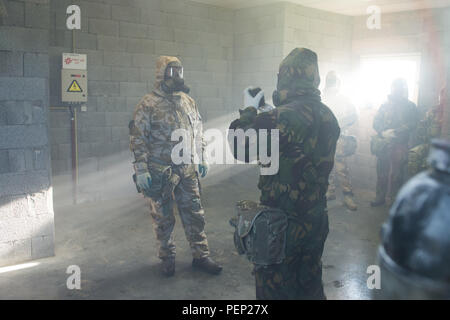 Ein Mitglied der Britischen Streitkräfte zu einer lokalen Einheit Austausch einen der Filter seiner Allgemein Atemschutz innerhalb der US-Army Training Support Center Benelux chemischen, biologischen, radiologischen und nuklearen Kammer auf chièvres Air Base, Belgien, Jan. 19, 2016. (U.S. Armee Foto von visuellen Informationen Spezialist Pierre-Etienne Courtejoie/Freigegeben) Stockfoto