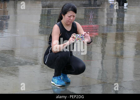 Trafalgar Square. London. 16. Aug 2018. UK Wetter: - eine Frau nimmt ein Foto von Nelson's Column während der schweren Regenguß in der Hauptstadt. Credit: Dinendra Haria/Alamy leben Nachrichten Stockfoto