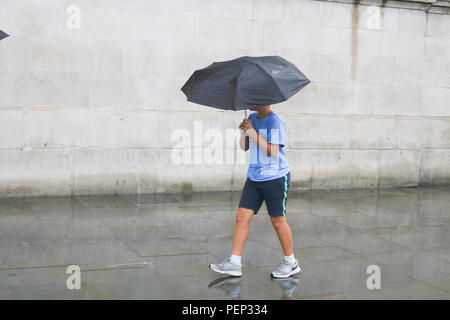 London, 16. August 2018. Fußgänger sind in strömendem Regen Unwetter in Trafalgar Square an einem regnerischen Sommertag Credit: Amer ghazzal/Alamy Leben Nachrichten gefangen Stockfoto