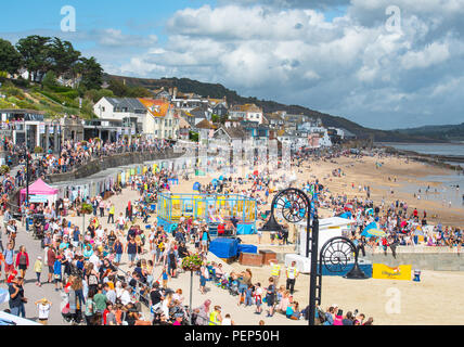 Lyme Regis, Dorset, Großbritannien. 16. August 2018. UK Wetter: warm, sonnig und Cloud in Lyme Regis. Massen der Urlauber und Besucher strömen zum Strand wie die der RAF Falken militärischen Fallschirm display Team drop auf den Strand in der Küstenstadt Lyme Regis. Die Anzeige ist eine von vielen Veranstaltungen für heute Ich liebe Lyme Tag. Credit: Celia McMahon/Alamy Leben Nachrichten. Stockfoto