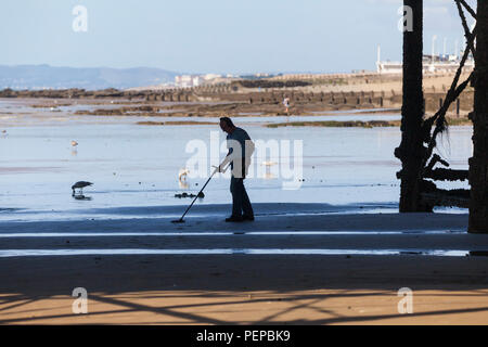 Hastings, East Sussex, Großbritannien. August 2018. UK Wetter: Heißer und sonniger Morgen in Hastings, East Sussex mit vielen Leuten am Strand. Die Temperaturen werden voraussichtlich über 21 Grad Celsius betragen Ein Detectorist durchläuft den Strand auf der Suche nach verlorenen Schätzen mit einem Metalldetektor, während die Flut am Strand unter dem Pier ist. © Paul Lawrenson 2018, Bildnachweis: Paul Lawrenson / Alamy Live News Stockfoto