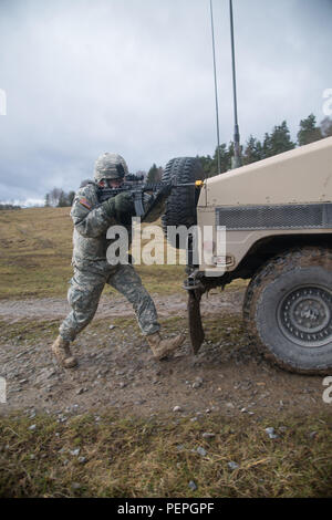 Ein US-Soldat, 554Th Military Police Company zugewiesene Feuer liefert an der Szene eines aufgeschlüsselt Humvee, nachdem sie unter Feuer von den Kräften der Opposition während der Wiederherstellung des Fahrzeugs Ausbildung kommen, Teil eines Feldes Training übung in Boeblingen lokale Schulungen, Jan. 13, 2016. (U.S. Armee Foto von visuellen Informationen Spezialist Martin Greeson/Freigegeben) Stockfoto