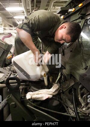Ein U.S. Marine mit Kampflogistik-Bataillon 26, 26. MEU, fügt einem 7-Tonnen-Lkw während der planmäßigen Wartung an Bord der USS Arlington (LPD 24) bei der Naval Support Activity Bahrain am 15. Januar 2016 Motoröl hinzu. Der Betrieb gewährleistet die Fahrzeugbereitschaft und unterstützt die logistischen Fähigkeiten. Die 26. MEU, die zusammen mit der Kearsarge Amphibious Ready Group eingesetzt wird, führt regionale Sicherheits-, Amphibien- und Seeverkehrsoperationen durch und führt routinemäßige mechanische und Instandhaltungsaufgaben aus, um die betriebliche Effizienz zu gewährleisten. Stockfoto