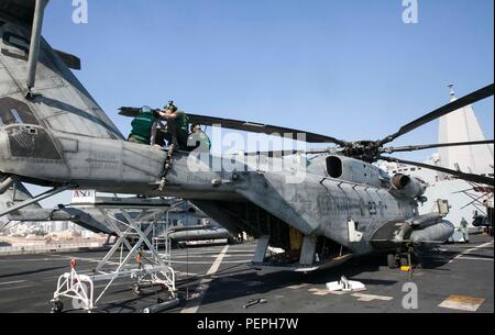 US-Marines von VMM-162 (verstärkt), 26. MEU, entfernen Rotorband von einem CH-53E Super Stallion Hubschrauber an Bord der USS Arlington (LPD 24), während sie am 15. Januar 2016 bei Naval Support Activity Bahrain angedockt waren. Der CH-53E, angetrieben von drei T64-GE-416 Turbowellenmotoren, wird routinemäßig gewartet, um die Flugbereitschaft zu gewährleisten. Die 26. MEU, die zusammen mit der Kearsarge Amphibious Ready Group eingesetzt wurde, führt regionale Sicherheit, amphibische Operationen und Unterstützung von Helikoptern im Gebiet der 5. US-Flotte durch. Stockfoto