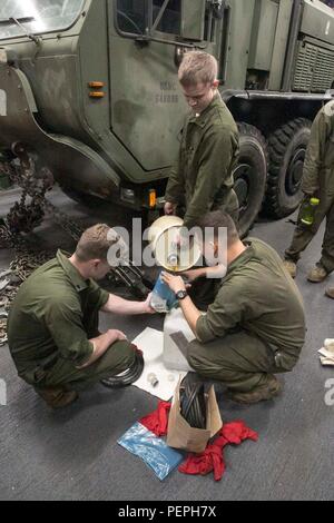 Die US-Marines mit dem Kampflogistik-Bataillon 26, 26. MEU mischen Motoröl während der planmäßigen Wartung an Bord der USS Arlington (LPD 24) bei der Naval Support Activity Bahrain am 15. Januar 2016. Dieses Verfahren gewährleistet die Betriebsbereitschaft der Fahrzeuge und unterstützt logistische Aufgaben. Die 26. MEU, die zusammen mit der Kearsarge Amphibious Ready Group eingesetzt wird, sorgt für die regionale Sicherheit und unterstützt maritime und amphibische Operationen bei mechanischer und technischer Wartung. Stockfoto