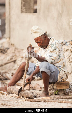 Stone Town, Sansibar, 17. Januar - 2015: Mann Holzhacken mit einem grossen Messer. Stockfoto