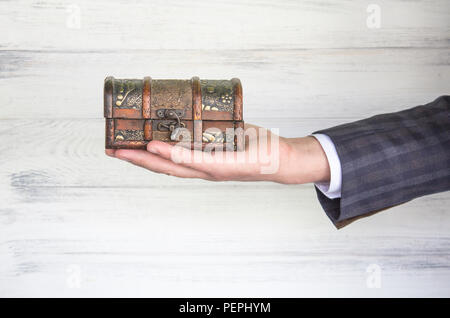 Antike Truhe (Antiquitäten) in der Hand eines Unternehmers. Stockfoto