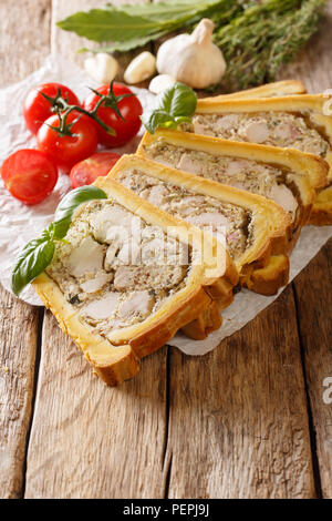 Hausgemachte Huhn Terrine, Jelly in Brot ist mit Basilikum und Gemüse in der Nähe serviert - auf den Tisch. Vertikale Stockfoto