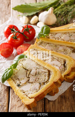 Huhn Terrine, Gelee, Aspik mit Brioche mit Kräutern und Gemüse in der Nähe serviert - auf den Tisch. Vertikale Stockfoto