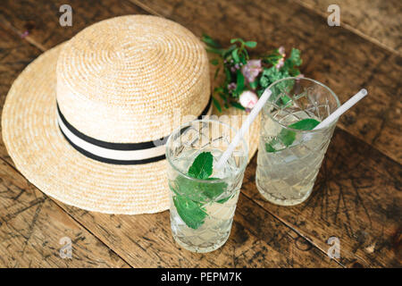 Straw hat und einen kleinen Blumenstrauß auf dem Tisch Stockfoto