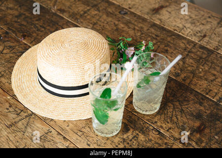 Straw hat und einen kleinen Blumenstrauß auf dem Tisch Stockfoto