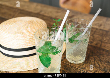 Straw hat und einen kleinen Blumenstrauß auf dem Tisch Stockfoto