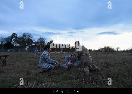 Pfc. Robert Foster (rechts) und SPC. Jennifer Ramirez (links), 212Th Combat Support Hospital (CSH) Ärzte, Bewertung eine Rolle Spieler Unfall außerhalb der CSH Tor während 30 medizinische Brigade MEDSHOCK Übung in Finthen LTA, Deutschland, Jan. 27, 2016. Übungen wie diese helfen, Test medizinische Interoperabilität zwischen der NATO zusammengeschlossen, Nationen. (U.S. Armee Foto vom Kapitän Jeku Arce, 30 medizinische Brigade Public Affairs/freigegeben) Stockfoto