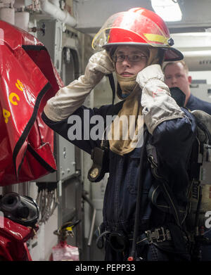 Am 24. Januar 2016 führten Seeleute an Bord der USS William P. Lawrence (DDG 110) eine allgemeine Übung im Pazifik durch und trugen Feuerwehrausrüstung an, um Notfallmaßnahmen zu üben. Der Zerstörer, der der Stennis Strike Group zugeordnet ist und mit der Großen Grünen Flotte operiert, hält eine kampfbereite Haltung für die maritime Sicherheit und den Einsatz im Westpazifik, was die Bereitschaft der Besatzung für betriebliche Notfälle und die Sicherheit an Bord verbessert. Stockfoto