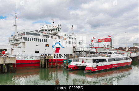 Red Funnel Fähren - Rot Jet 4 Katamaran Fähre und Red Falcon Autofähre an den Southampton Docks in Southampton, Hampshire, England, UK. Stockfoto