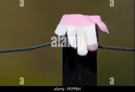 Einen einzigen verlorenen Handschuh auf ein Post nach gefunden wird. Konzept verloren. Stockfoto