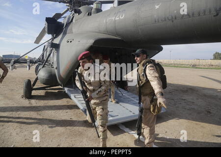 Eine irakische Trainer leitet irakische Soldaten nach Ninive Operations Command Commando Bataillon beim Verlassen einer irakischen Mi-17 SH 'Black Beauty' Helikopter im Camp Taji, Irak, Jan. 11, 2016 zugeordnet. Das Combined Joint Task Force - Betrieb die Ausbildung ist entscheidend für die Aktivierung der irakischen Sicherheitskräfte gegen die Islamischen Staat im Irak und der Levante, wie sie arbeiten, sie Kämpfen zu besiegen und ISIL zerstören. (U.S. Armee Foto von SPC. William Lockwood/Freigegeben) Stockfoto