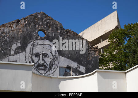 Wandmalerei des bosnischen Dichters Aleksa Santic auf einen Krieg beschädigte Haus in Mostar, Bosnien und Herzegowina. Die 'Sniper Turm' im Hintergrund ist. Stockfoto