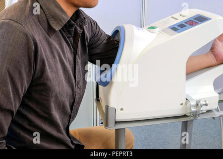 Männliche Patienten legen Sie Ihren linken Arm in den Druck überwachen. Der Blutdruck und die Herzfrequenz zu prüfen. Stockfoto