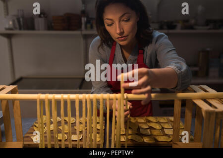 Weibliche baker Zubereitung Nudeln in Bäckerei Stockfoto