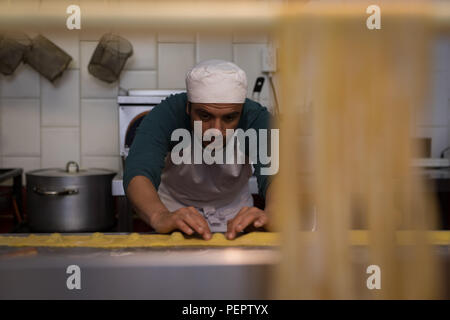 Männliche baker Zubereitung Nudeln in Bäckerei Stockfoto