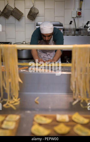 Männliche baker Zubereitung Nudeln in Bäckerei Stockfoto