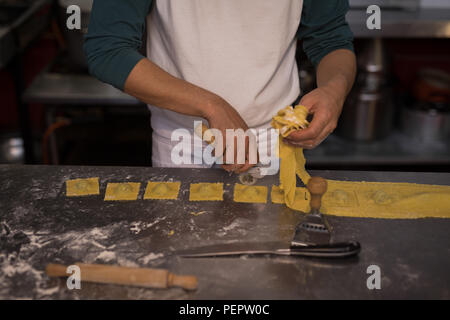 Männliche baker Zubereitung Nudeln in Bäckerei Stockfoto