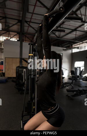 Frau Zug tut ups in Fitness Gym Stockfoto