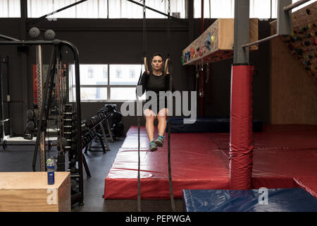 Frau Zug tut ups auf Gymnastik Ringe in Fitness Gym Stockfoto