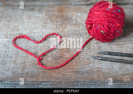 Leuchtend rote Tweed Wolle Garn mit Herz geformte Gewinde, Stricken Postkarte, getönt Stockfoto