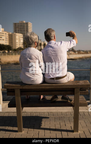 Senior Paar unter selfie während auf der Bank an der Promenade sitzen Stockfoto
