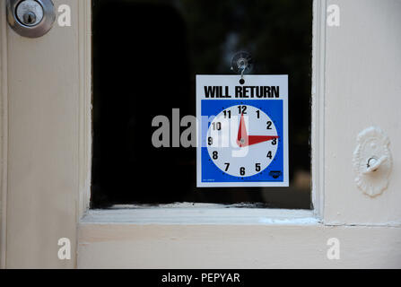 Ein 'Zurück'-Schild hängt an der Eingangstür von einem Ladengeschäft. Stockfoto