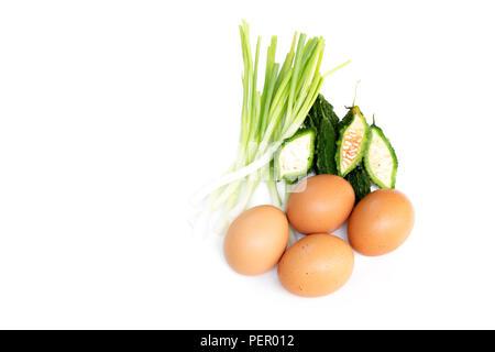 Bitterer Kürbis, Eier und Frühlingszwiebel solated auf weißem Hintergrund. Stockfoto