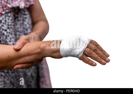 Ältere Frau Handverletzung mit Bandage in Freistellungspfad isoliert. Stockfoto