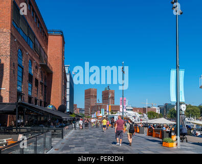 Cafés, Bars, Restaurants und Geschäfte auf Stranden, in der Hafengegend mit Blick in Richtung Rådhusplassen und City Hall, Aker Brygge, Oslo, Norwegen Stockfoto