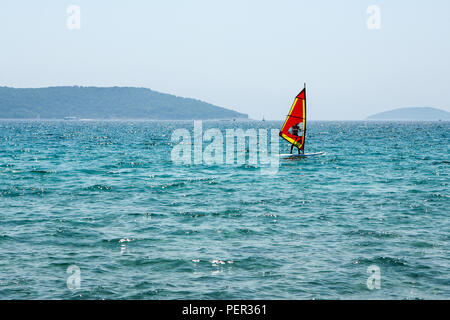 Ein Bild von einem einzigen Windsurfen auf dem Meer während der heißen Sommertag. Dargestellt in Kroatien. Stockfoto