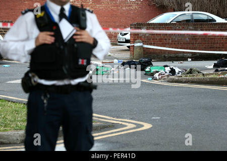 Ein Polizist bewacht den Bereich der Landor Haus, Camberwell, London, nach vier Menschen zum Krankenhaus mit Stichverletzungen getroffen wurden. Fünf Männer festgenommen worden. Stockfoto