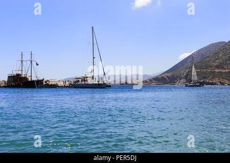 Weißes Segelboot auf dem offenen Meer. Segelyacht in das offene Meer mit den Bergen im Hintergrund. Stockfoto
