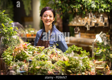 Junge Frau in Pflanzen shop arbeiten Stockfoto