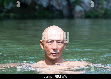 Stumpfe japanische Glatze Kerl getränkt im Fluss Stockfoto