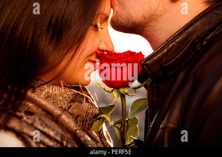 Frohes und liebevolles Paar für Valentinstag. Amorous Kerl sanft küssen sein Mädchen in der Stirn, während sie genießt. Stockfoto
