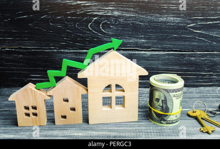 Holz- Häuser stehen in einer Reihe von klein bis groß mit einem grünen Pfeil nach oben. Konzept der hohe Nachfrage nach Immobilien. zur Steigerung der Energieeffizienz der Wohnungen. Stockfoto